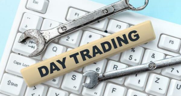 Two wrenches sit on a keyboard with a strip of wood that says "Day Trading On It"